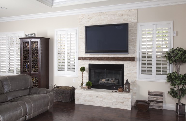 White plantation shutters in a Charlotte living room with plank hardwood floors.